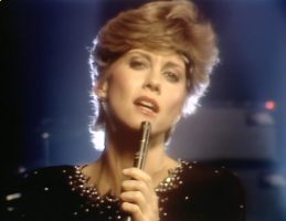 Olivia Newton-John performs Love Make Me Strong on Physcial videogram